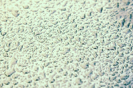 Water drops on metal background with reflection blurred on the edges. Image processing with color filter effectの写真素材