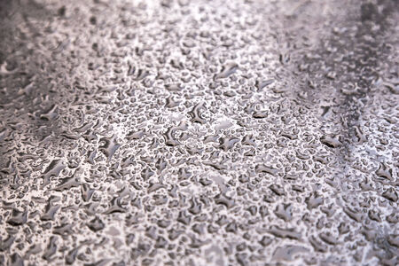 Water drops on metal background with reflection blurred on the edges.の写真素材