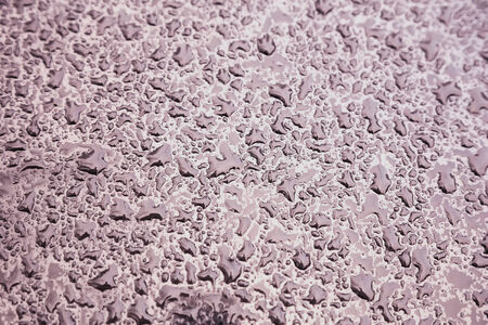 Water drops on metal background with reflection blurred on the edges. Image processing with color filter effectの写真素材