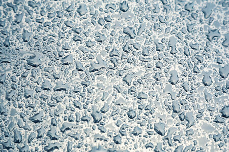 Water drops on metal background with reflection blurred on the edges. Image processing with color filter effectの写真素材