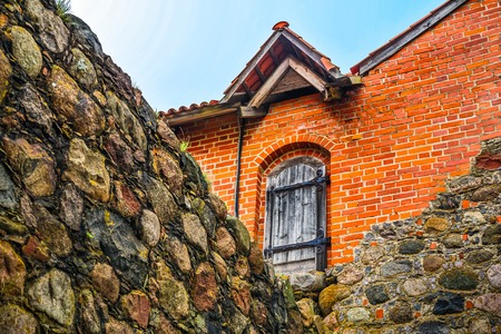 Wooden door in red bricks wall surrounding stone wallのeditorial素材