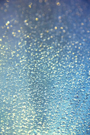 Water drops on metal background with reflection blurred on the edges. Image processing with color filter effectの写真素材