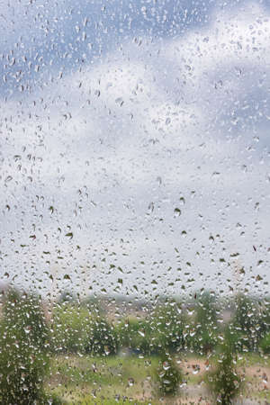 Water drops on window glass, blurred on the edgesの写真素材