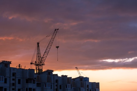 Silhouette of construction crane on dramatic sky background at the sundownのeditorial素材