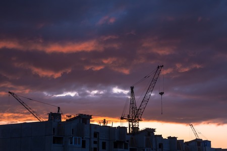 Silhouette of construction crane on dramatic sky background at the sundownのeditorial素材