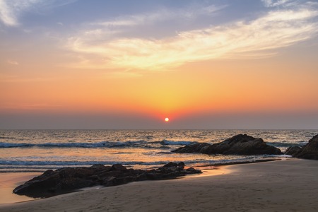 Scenic view from sand beach in Goa to beautiful sunset above the Arabian seaの写真素材