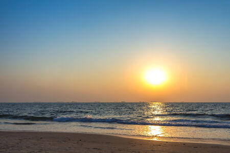 Scenic view from sand beach in Goa to beautiful sunset above the Arabian sea. Sun reflection on sea surfaceの写真素材