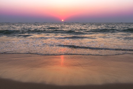 Scenic view from sand beach in Goa to beautiful sunset above the Arabian seaの写真素材