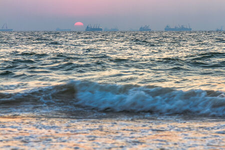 Scenic view of beautiful sunset above the Arabian sea. Cargo ship on the backgroundの写真素材