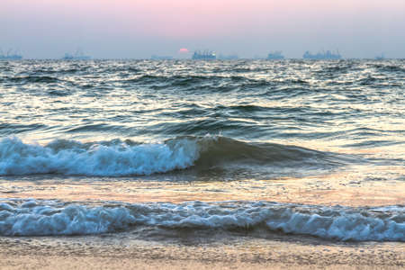 Scenic view of beautiful sunset above the Arabian sea. Cargo ship on the backgroundの写真素材