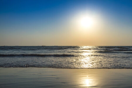 Scenic view from beach in Goa to beautiful sunrise above the Arabian sea. Sun reflection on sea surfaceの写真素材