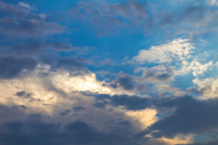 Sun under clouds on blue sky backgroundの写真素材