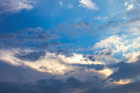 Sun under clouds on blue sky backgroundの写真素材