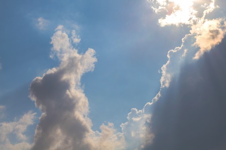 Sun under clouds on blue sky backgroundの写真素材