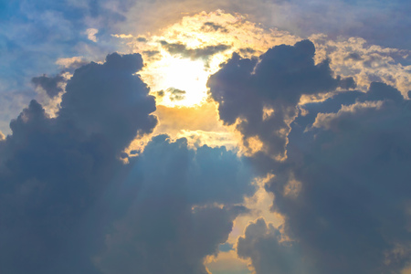 Sun under clouds on blue sky backgroundの写真素材