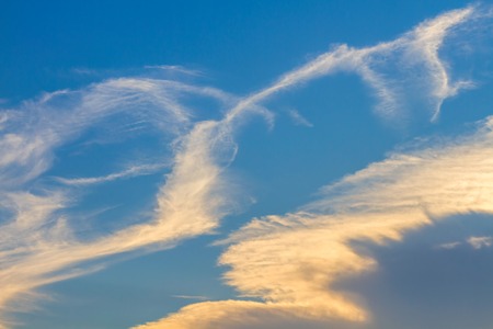 White and orange clouds on blue sky backgroundの写真素材