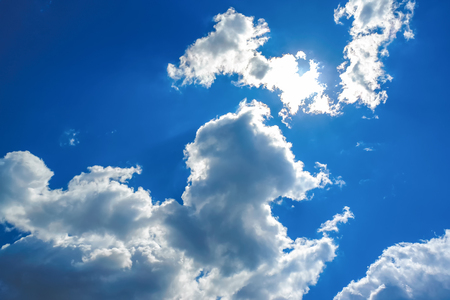 Sun under clouds on blue sky backgroundの写真素材
