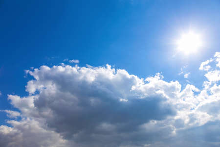 Sun and white clouds on blue sky backgroundの写真素材