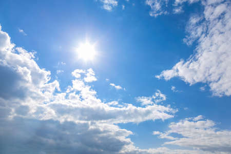 Sun and white clouds on blue sky backgroundの写真素材