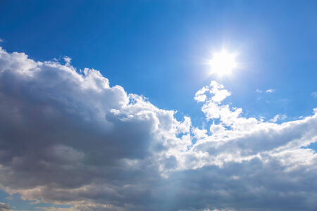 Sun and white clouds on blue sky backgroundの写真素材
