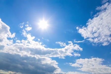 Sun and white clouds on blue sky backgroundの写真素材