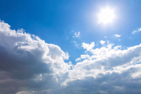 Sun and white clouds on blue sky backgroundの写真素材