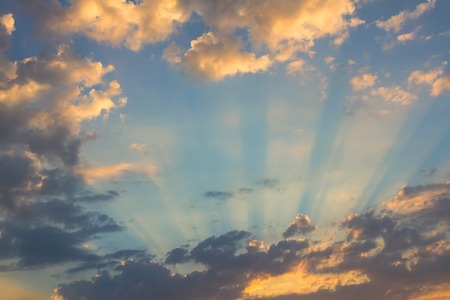 Sun under clouds on blue sky backgroundの写真素材