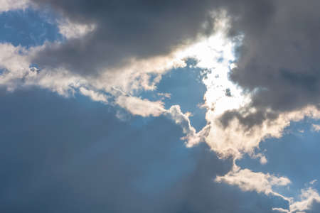 Sun under clouds on sky backgroundの写真素材