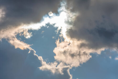 Sun under clouds on sky backgroundの写真素材