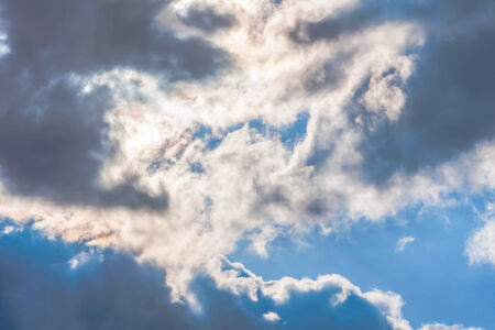 Sun under clouds on sky backgroundの写真素材