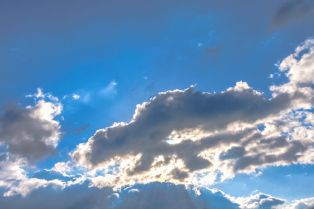 Sun under clouds on blue sky backgroundの写真素材