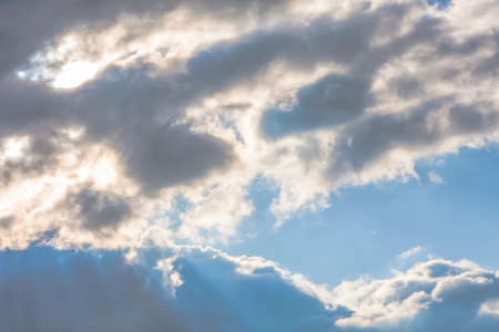 Sun under clouds on sky backgroundの写真素材
