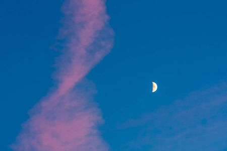 Moon or crescent on blue sky background with pink cloudsの写真素材