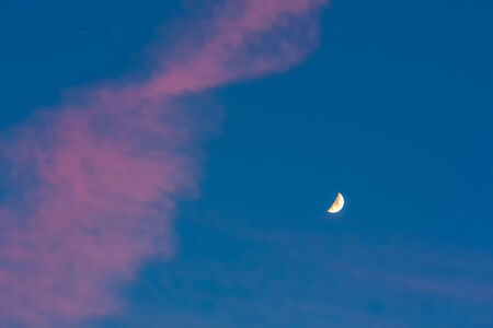 Moon or crescent on blue sky background with pink cloudsの写真素材