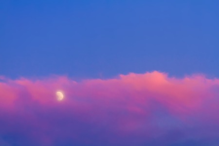 Moon under pink cloud on blue sky backgroundの写真素材
