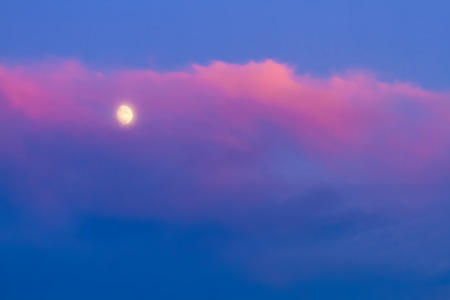 Moon under pink cloud on blue sky backgroundの写真素材