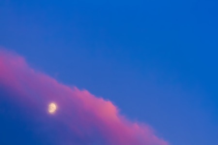 Moon under pink cloud on blue sky backgroundの写真素材