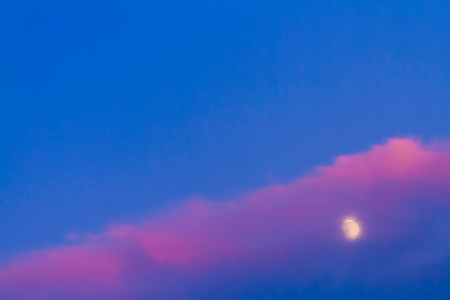 Moon under pink cloud on blue sky backgroundの写真素材