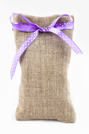 Decorative textile sachet pouch with a ribbon and bow on white backgroundの写真素材