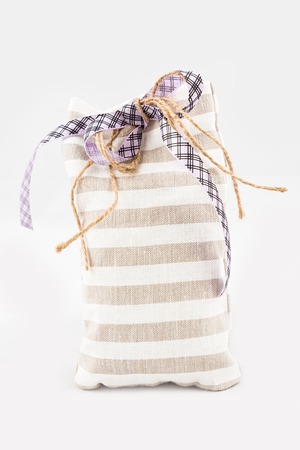 Decorative textile sachet pouch with a ribbon and bow on white backgroundの写真素材