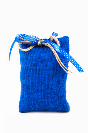 Decorative textile sachet pouch with a ribbon and bow on white backgroundの写真素材