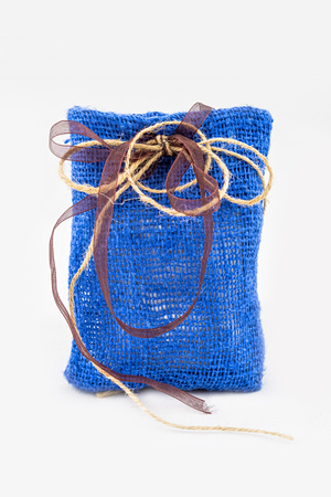 Decorative textile sachet pouch with a ribbon and bow on white backgroundの写真素材