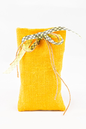 Decorative textile sachet pouch with a ribbon and bow on white backgroundの写真素材