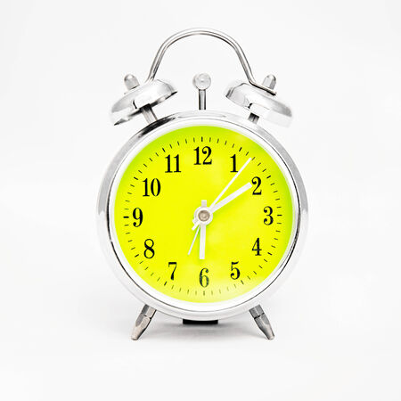 Alarm clock on white background. Showing time ten minutes past sixの写真素材