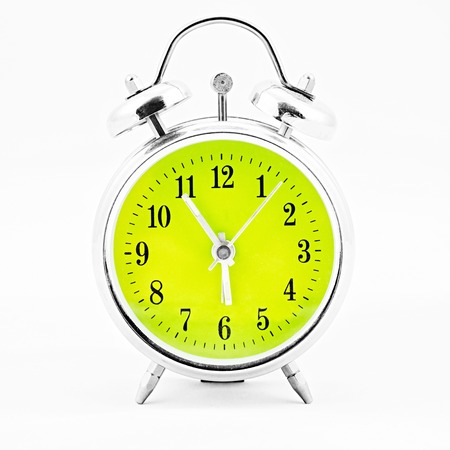 Alarm clock on white background. Showing time five minutes before sixの写真素材