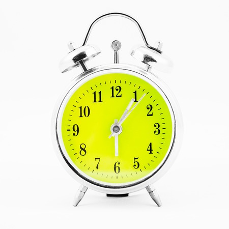 Alarm clock on white background. Showing time five minutes past sixの写真素材