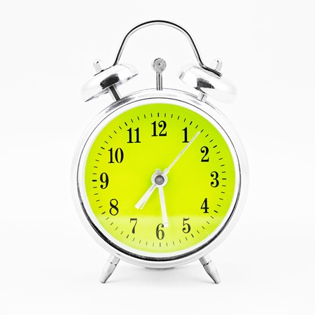 Alarm clock on white background. Showing time twenty eight minutes past sevenの写真素材