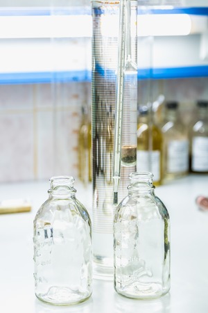 Empty glass bottles on table. Research laboratory glasswareの写真素材