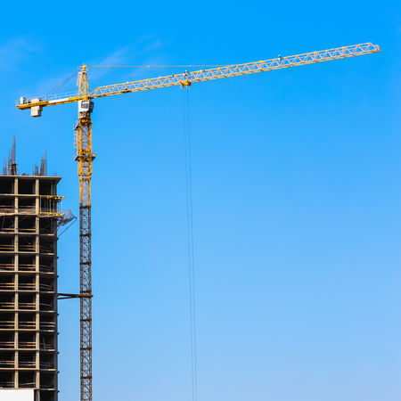 Construction crane on building site on sky backgroundの写真素材