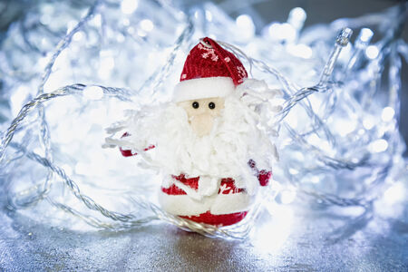 Santa Claus or Father Frost with Christmas lights at background on silver or metal grunge surfaceの写真素材